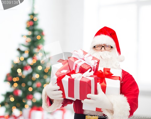 Image of man in costume of santa claus with gift boxes