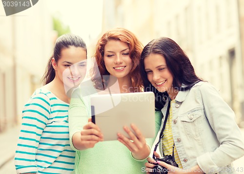 Image of smiling teenage girls with tablet pc and camera