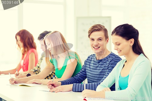 Image of smiling students with textbooks at school