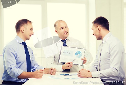 Image of smiling businessmen with papers in office