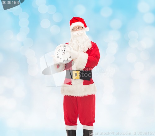 Image of man in costume of santa claus with clock