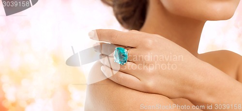 Image of closeup of woman hand with big blue cocktail ring