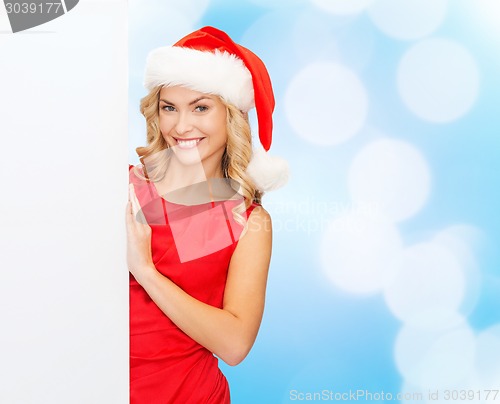 Image of smiling young woman in santa hat with white board