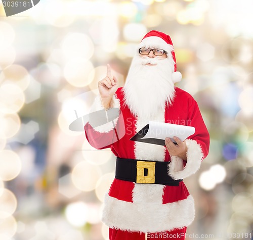 Image of man in costume of santa claus with notepad