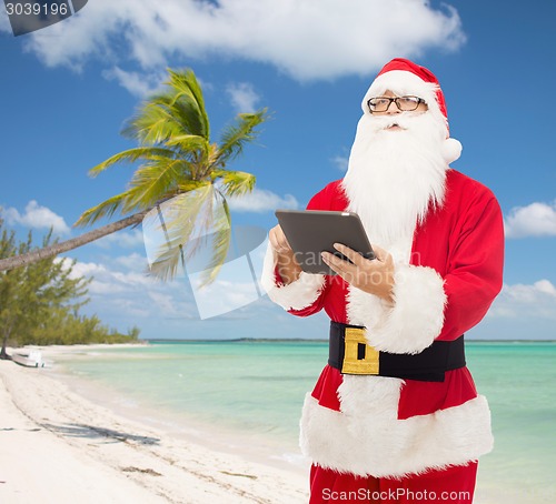 Image of man in costume of santa claus with tablet pc