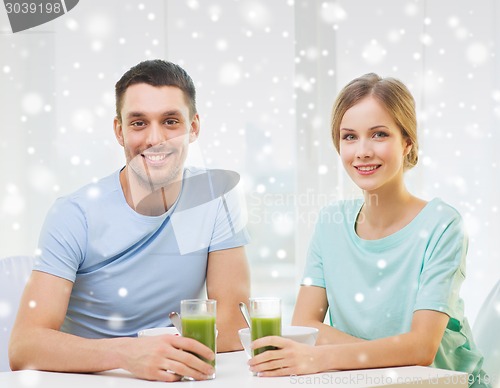 Image of smiling couple having breakfast at home