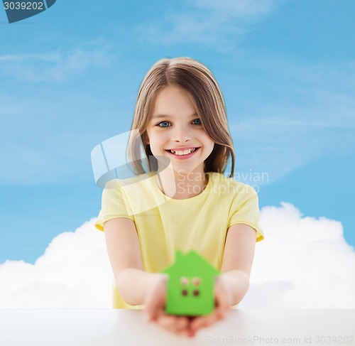 Image of beautiful little girl holding paper house cutout