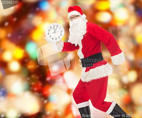 Image of man in costume of santa claus with clock