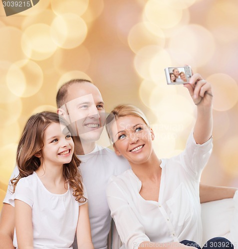 Image of happy family with camera at home