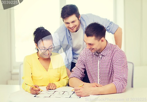 Image of three smiling architects working in office