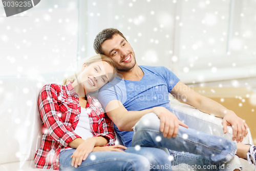 Image of smiling couple relaxing on sofa in new home