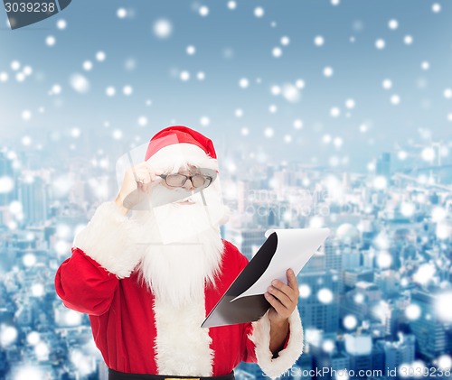 Image of man in costume of santa claus with notepad