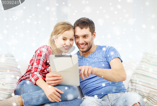 Image of smiling couple with tablet pc computer at home