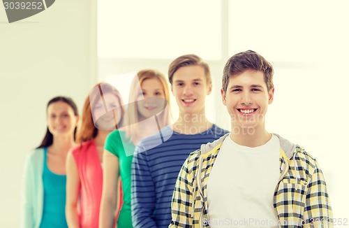 Image of smiling students with teenage boy in front