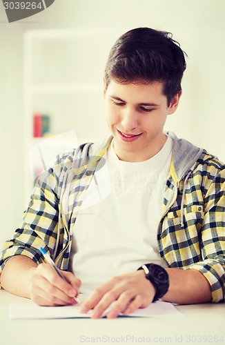 Image of smiling student with textbooks at school