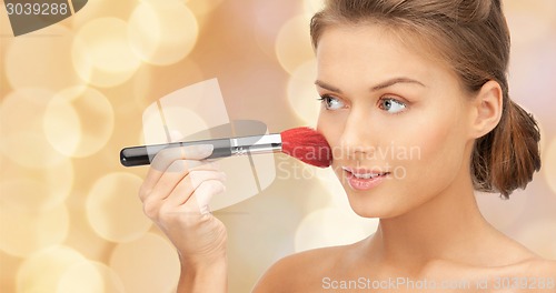 Image of beautiful smiling woman with make up brush