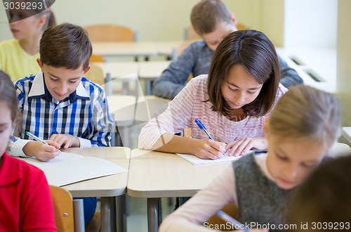 Image of group of school kids writing test in classroom