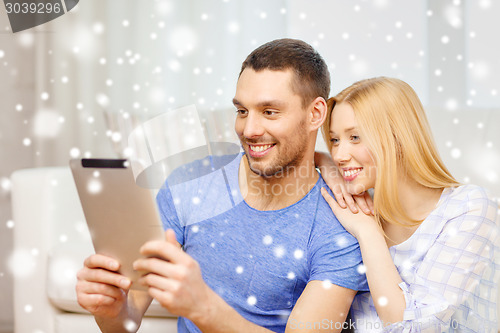 Image of smiling happy couple with tablet pc at home