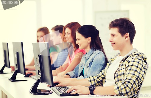 Image of male student with classmates in computer class