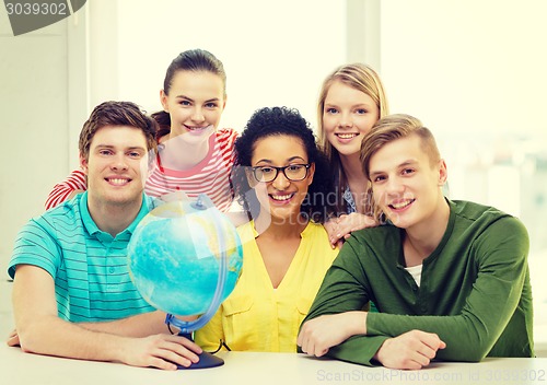 Image of five smiling student with earth globe at school