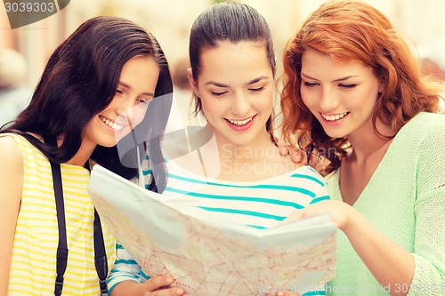 Image of smiling teenage girls with map and camera