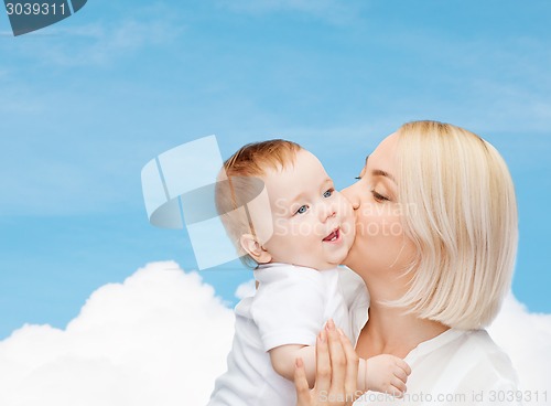 Image of happy mother kissing smiling baby