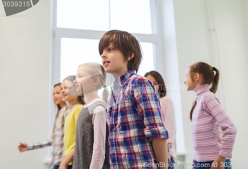 Image of group of smiling school kids walking in corridor