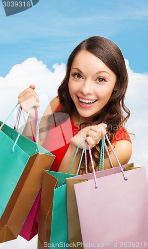 Image of smiling woman with colorful shopping bags