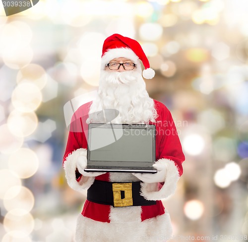 Image of man in costume of santa claus with laptop