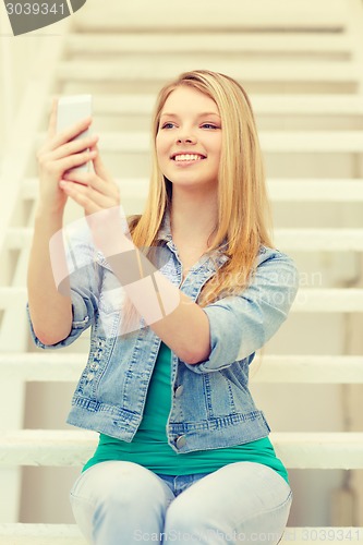 Image of smiling female student with smartphone
