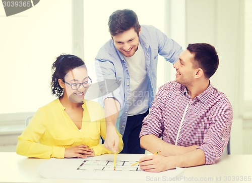 Image of three smiling architects working in office