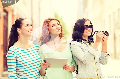 Image of smiling teenage girls with tablet pc and camera