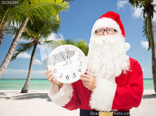 Image of man in costume of santa claus with clock