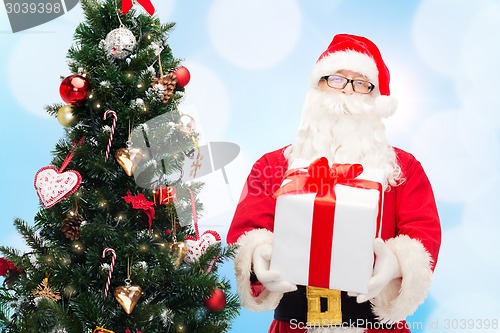 Image of man in costume of santa claus with gift box