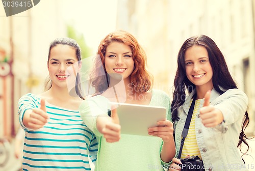 Image of smiling teenage girls with tablet pc and camera