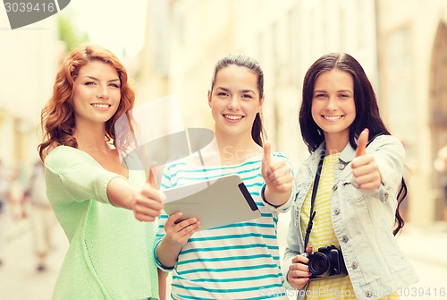 Image of smiling teenage girls with tablet pc and camera