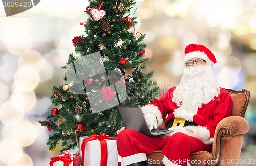 Image of man in costume of santa claus with laptop