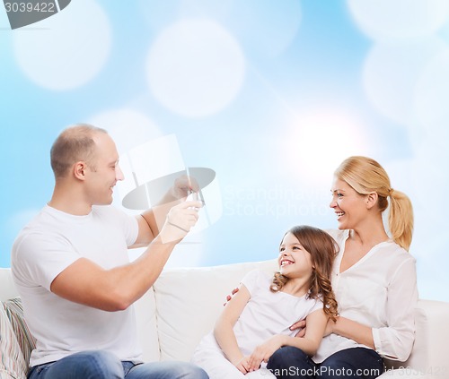 Image of happy family with camera at home