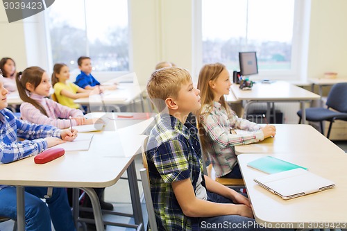 Image of group of school kids with notebooks in classroom