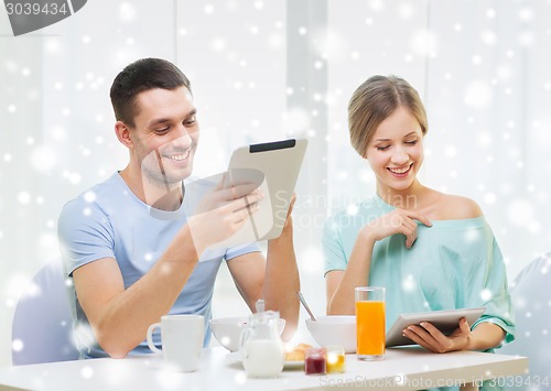 Image of smiling couple with tablet pc having breakfast