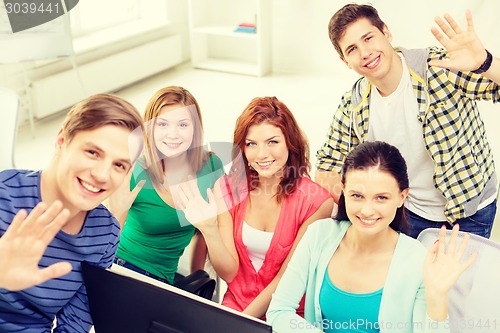 Image of group of smiling students waving hands at school