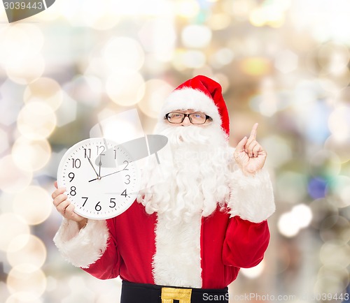 Image of man in costume of santa claus with clock