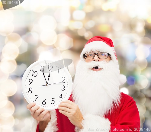 Image of man in costume of santa claus with clock