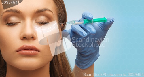 Image of close up of woman face and hand with syringe