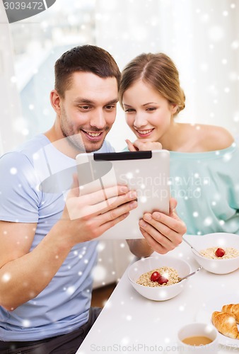 Image of smiling couple with tablet pc having breakfast