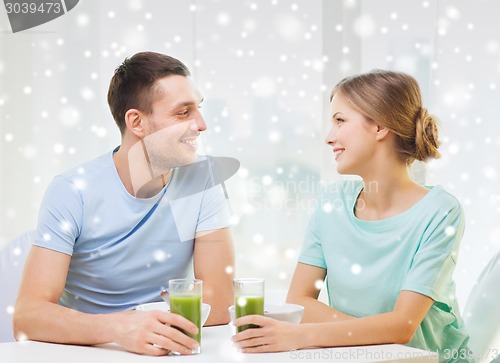 Image of smiling couple having breakfast at home