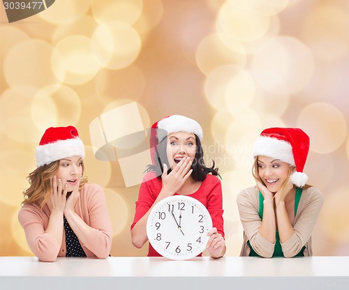 Image of smiling women in santa helper hats with clock