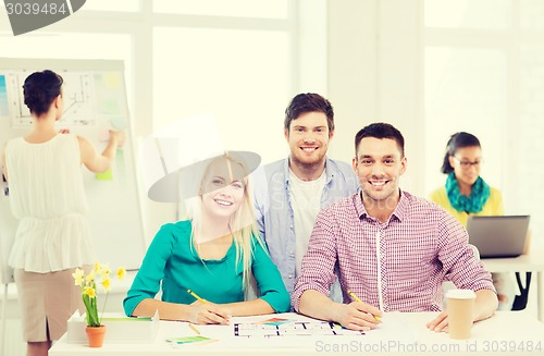 Image of smiling interior designers working in office