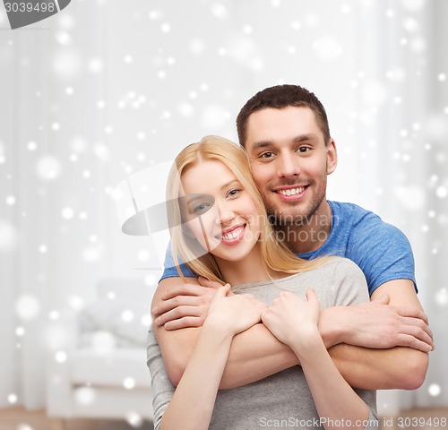 Image of happy couple hugging at home