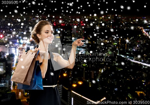 Image of smiling woman in dress with shopping bags